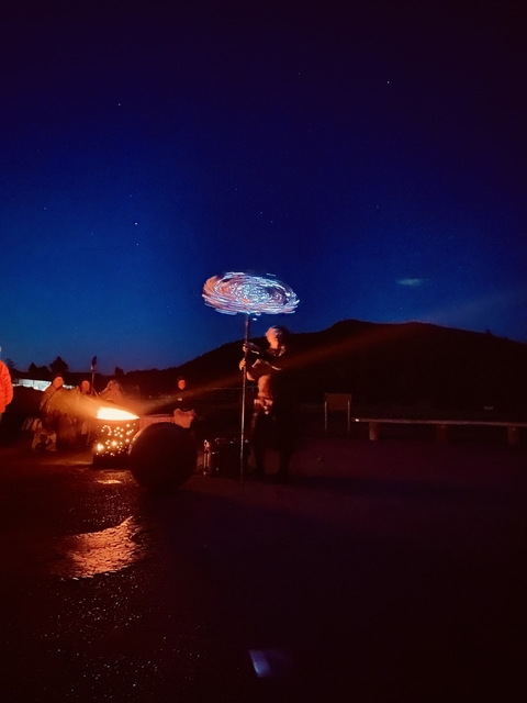 Person performing with LED poi lights at night.