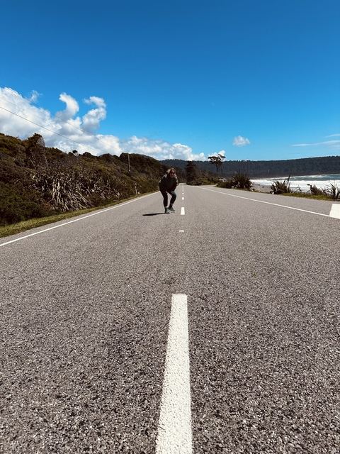 Person running on a road along the coastline.