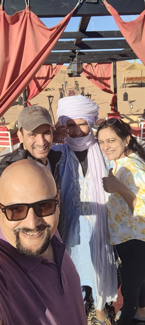 Group of people posing for a selfie outdoors.