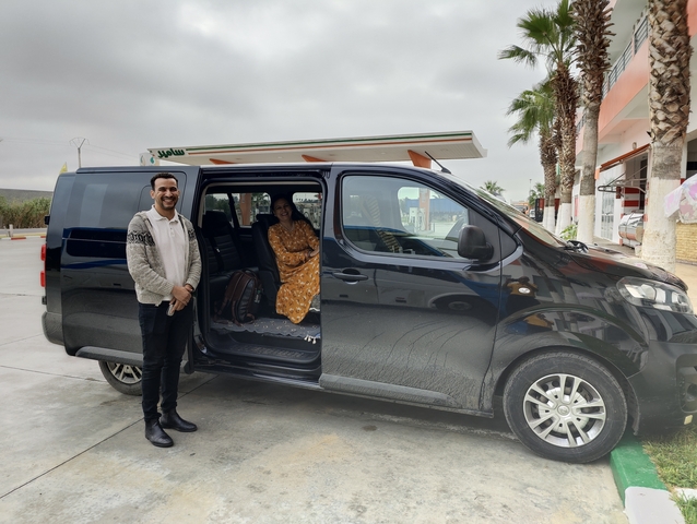 People standing by a van in a roadside setting.