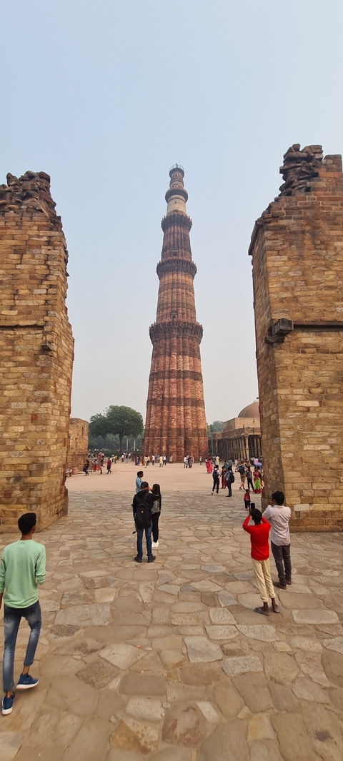 View of Qutub Minar with people around.