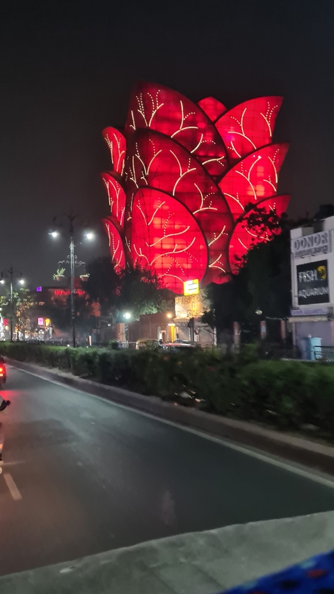 A city night scene with a large red-lit structure.