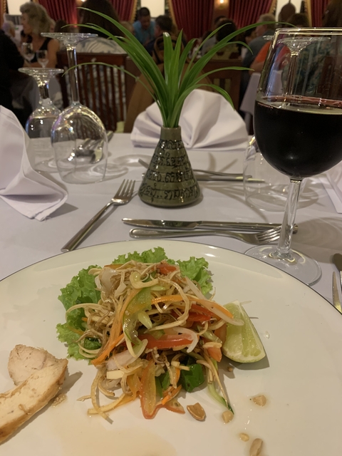 Salad and wine glass on an elegantly set table.