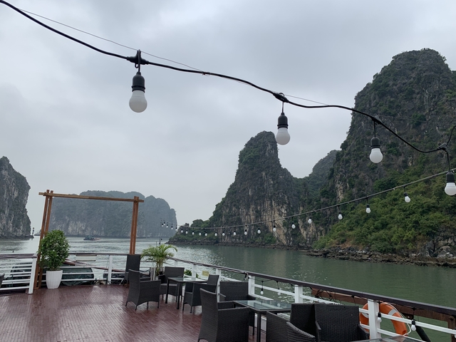 Calm bay with limestone formations and string lights.