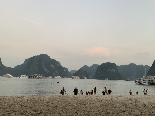 Beachside view of Halong Bay with boats.