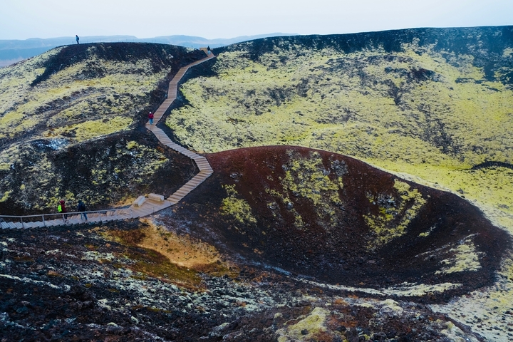 Scenic hiking trail winding through a colorful volcanic hill.