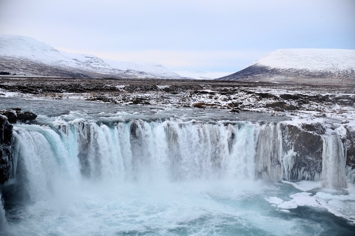 Stunning frozen waterfall surrounded by a snowy landscape.