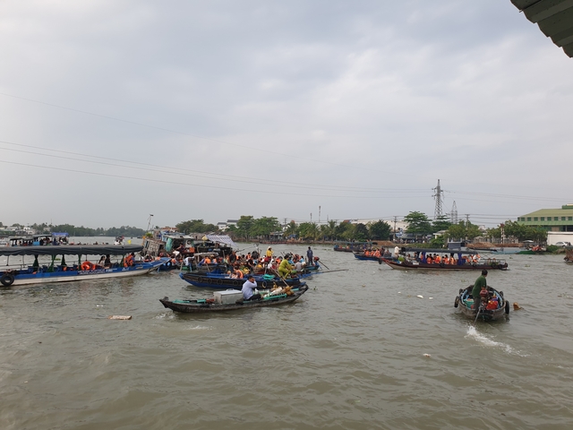 Busy river scene with numerous boats and people.