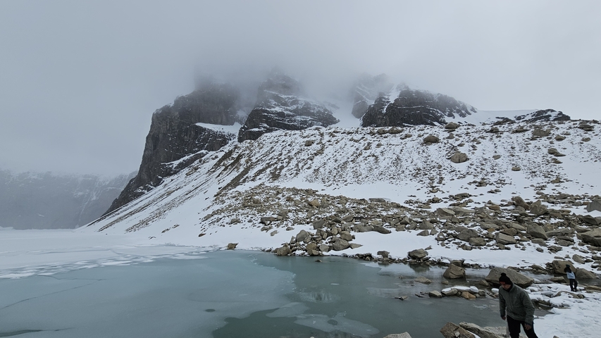 Cloudy mountain landscape with a person by a lake