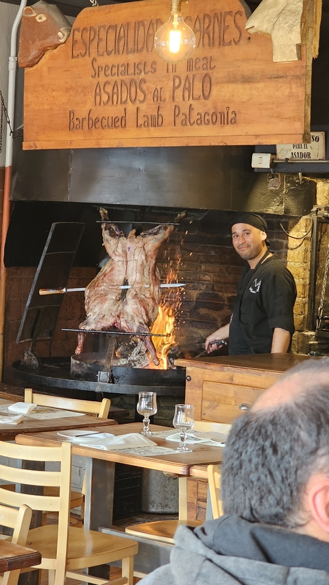 Chef standing in front of a roasting animal over fire