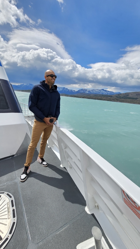 Person on a boat with scenic water and mountains in the background