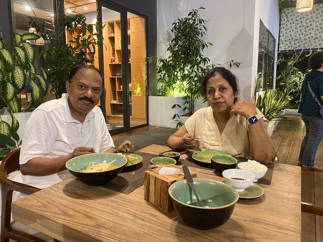 Couple enjoying a meal at an outdoor restaurant.