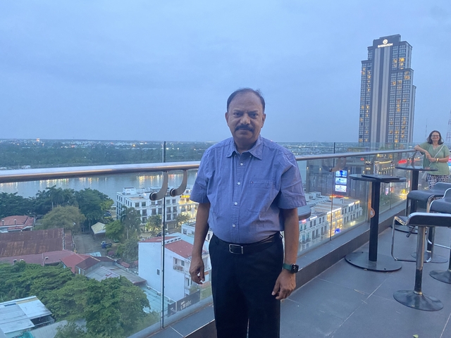 Man standing on a rooftop with cityscape views.