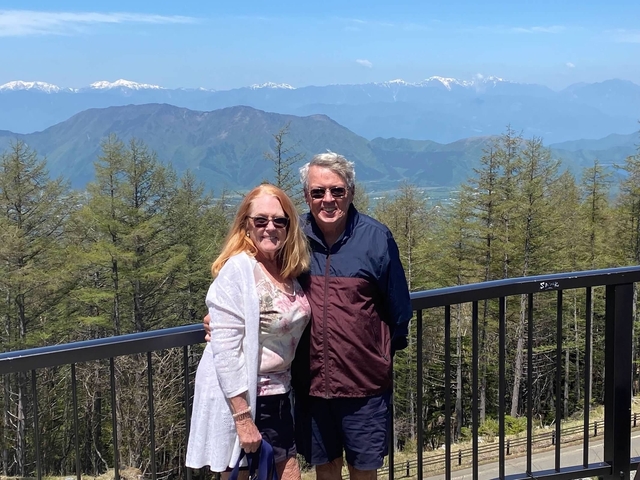 Two people with a mountain view in the background.