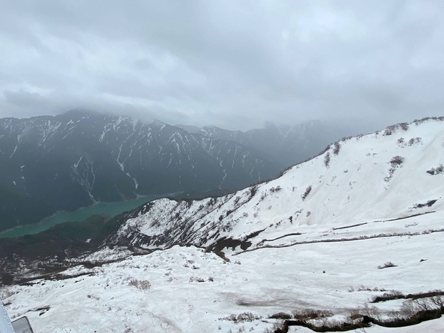 Snow-covered mountains with mist and lake.