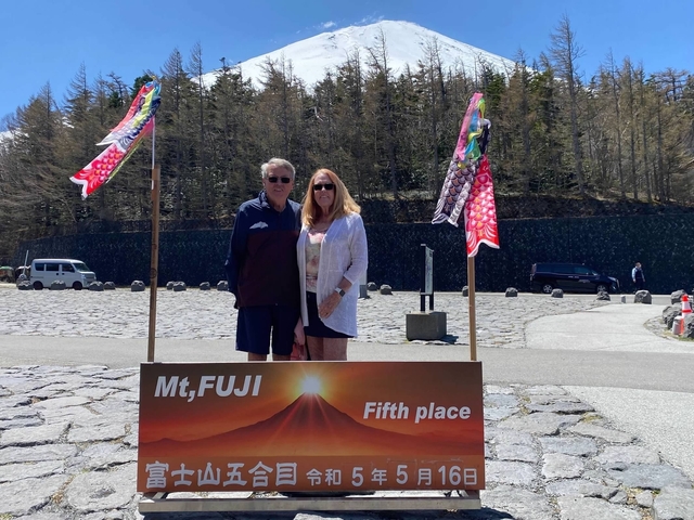 Two people posing with a Mt. Fuji sign.