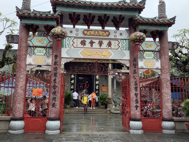 Ornate temple entrance with visitors and decorations.