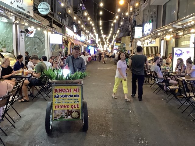 Bustling night market with people dining and walking.