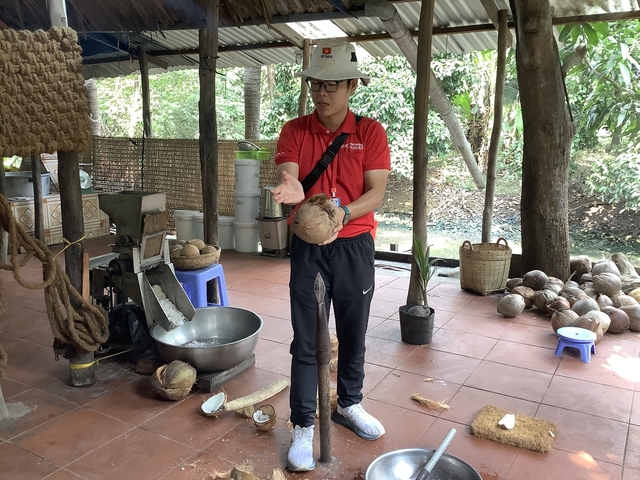 Person demonstrating coconut cracking in an outdoor setting.