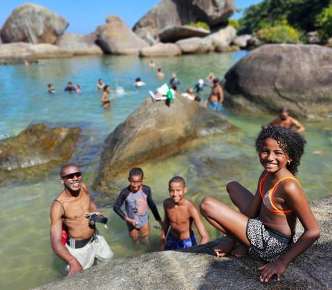 Group of people enjoying a swim in natural rock pools.