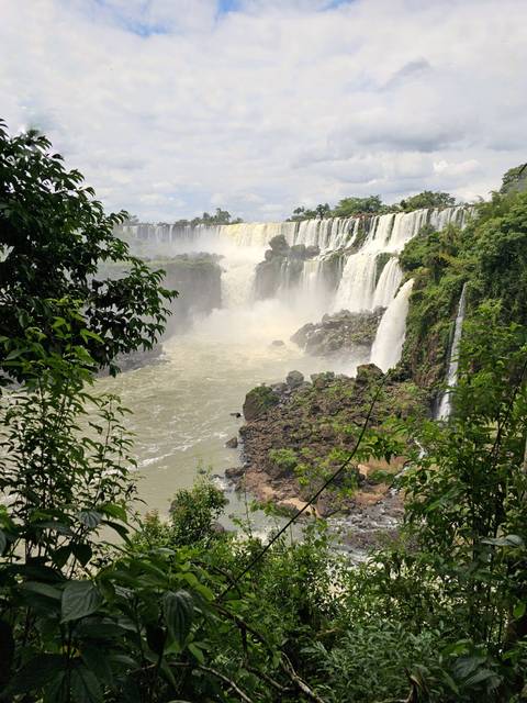 View of waterfalls surrounded by lush greenery.