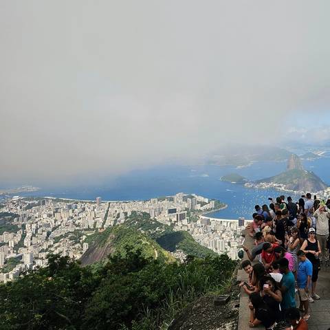 Panoramic view of a city with mountains and the sea.