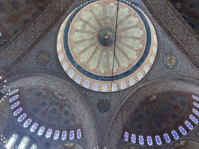Interior view of a mosque dome with intricate patterns.