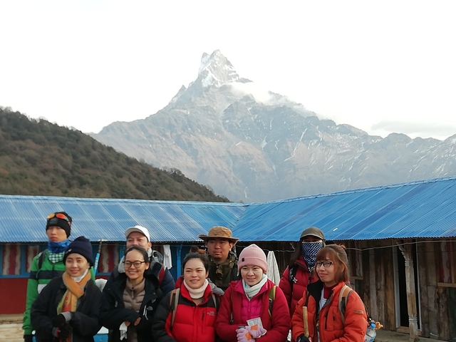 Group of people with a snow-capped mountain backdrop.