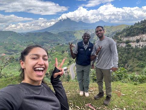 Group of people posing in a mountainous landscape.