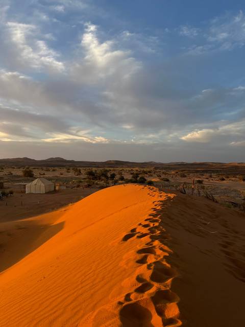 Desert dune against a vast open sky.