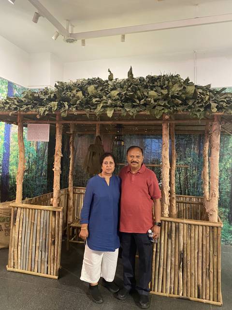 Couple posing in front of a bamboo and wood structure.