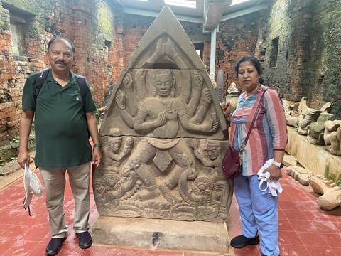 Upside-down photo of two individuals with ancient carvings.