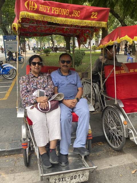 Couple sitting in a traditional rickshaw.