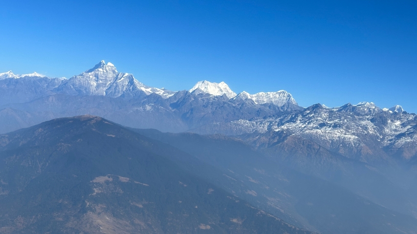 Panoramic view of snow-capped mountains with clear blue skies.