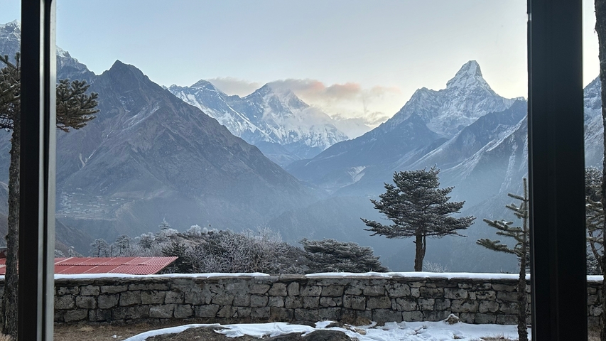 Mountain view with a stone wall and snowy peaks in the background.