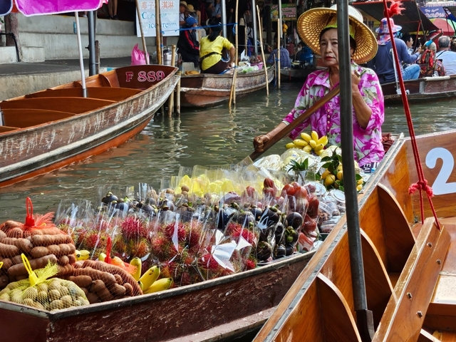 Floating market with several boats filled with fruits.