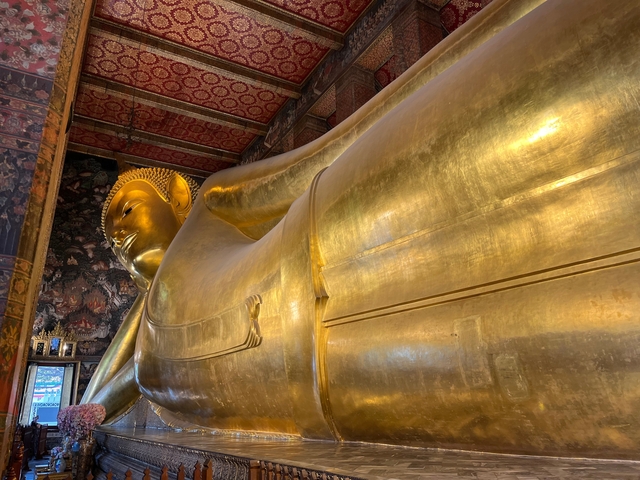 Large reclining golden Buddha statue inside a temple.