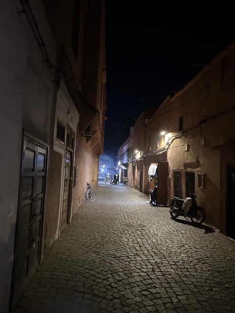 Narrow alleyway in a traditional Moroccan medina at night.