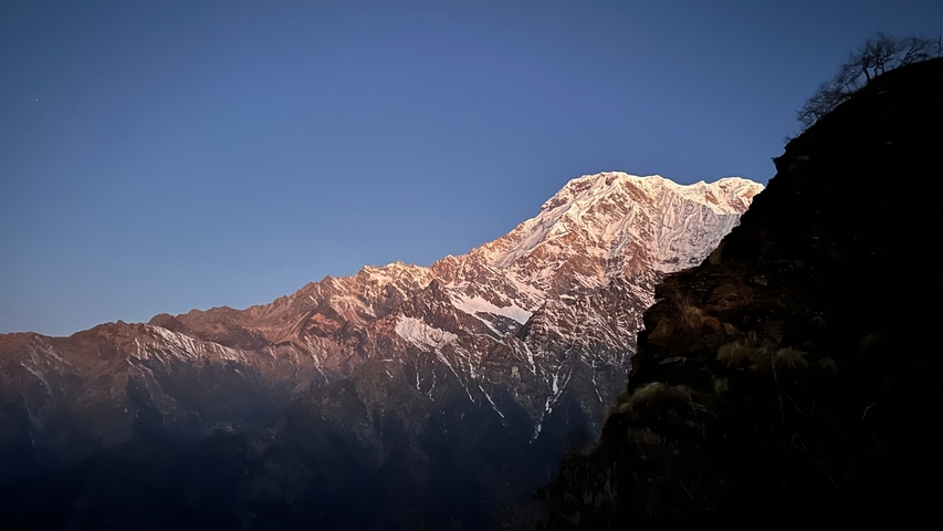 Scenic view of sunlit mountain peak at dusk.