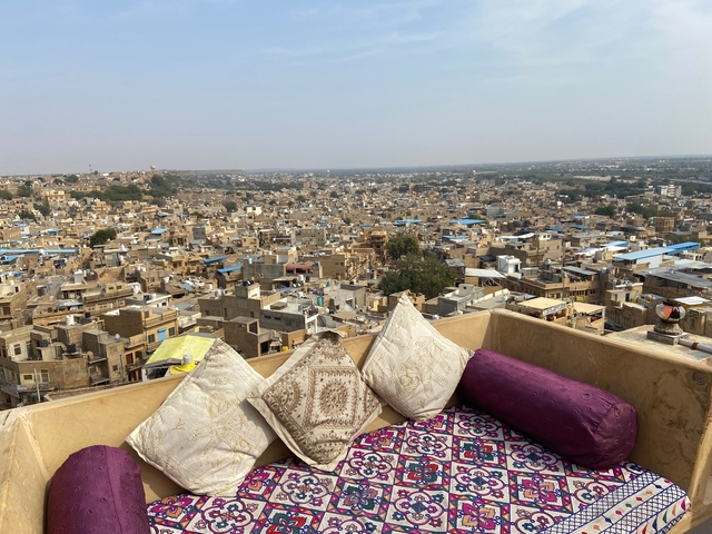 Scenic view of a densely packed city with a balcony in the foreground.