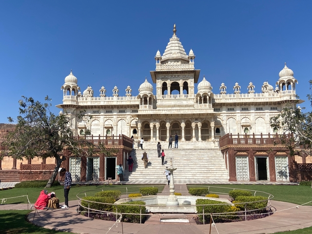 White ornate building set against a clear blue sky with visitors.