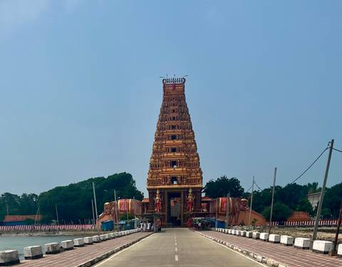 An ornate temple structure in a cultural setting with trees nearby.