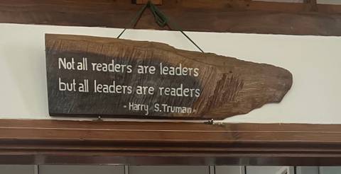 A wooden sign with a quote about leadership.