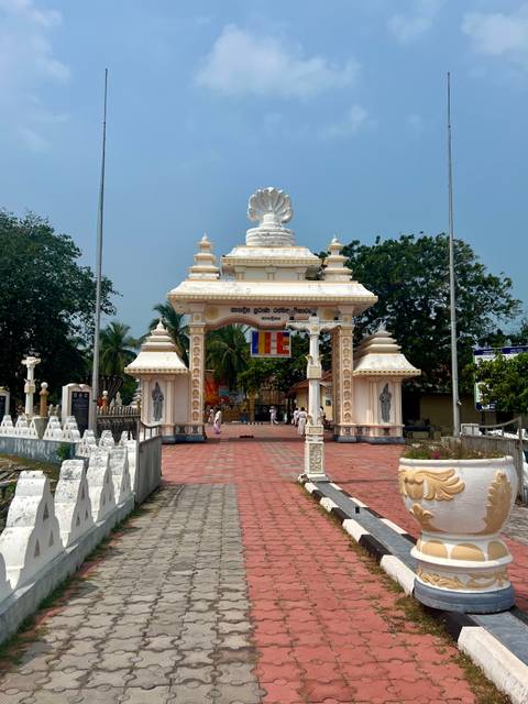 An entrance to a temple adorned with sculptures and text.