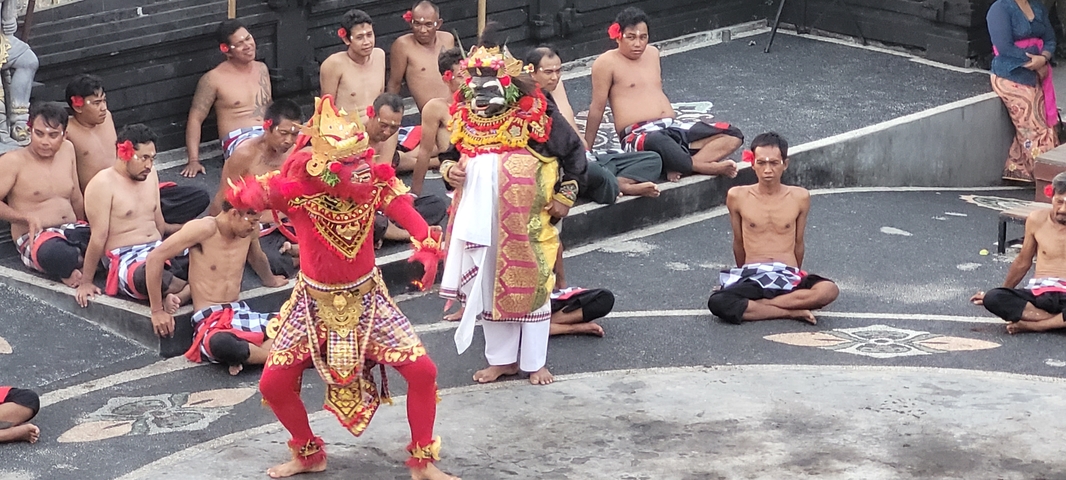 Traditional dancers in ornate costumes performing in an outdoor setting.