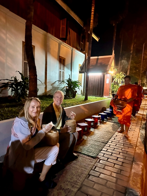 Couple participating in a monk offering ritual.
