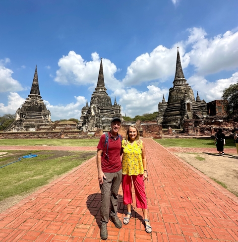 Couple standing in front of historical pagodas.