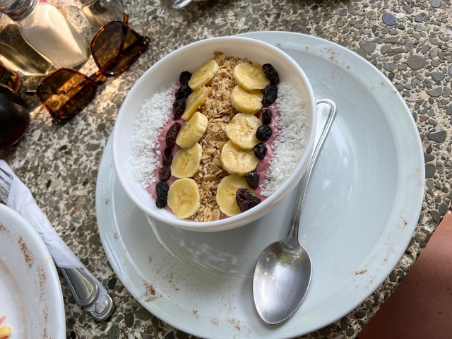 A bowl of smoothie topped with fruits and granola.