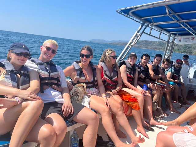 Group of people in life vests on a boat tour.