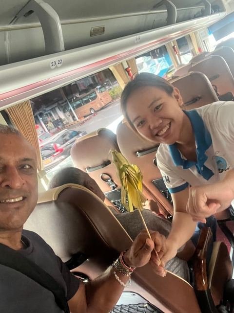 People smiling and having a conversation on a bus.